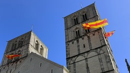 Auschnitt vom Dom in Münster mit rot/gelber Beflaggung. Anlass ist die Bekanntgebung des neuen Bischof in Münster.