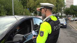 Ein Polizist spricht mit einem Autofahrer, den er offenbar angehalten hat. 