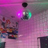 An der Decke einer öffentlichen Toilette hängt eine angestrahlte Discokugel