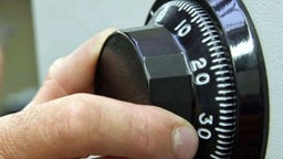 Hand dreht an Kombinationsschloss
