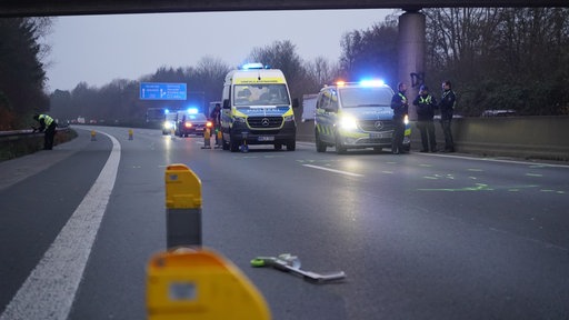 Polizisten und Polizeiautos stehen auf der Straße