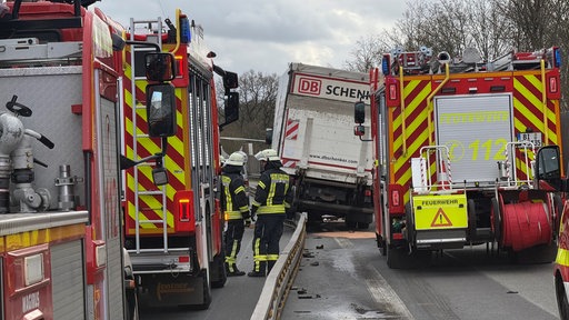 Ein Lkw steht in einer Leitplanke, die Feuerwehr ist auch da