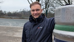 Ein Mann steht neben einem Bierfass