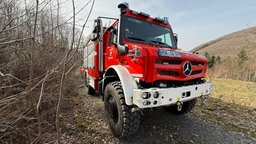 Ein Feuerwehrauto steht in einem Waldstück