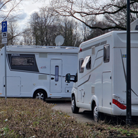 Ein Wohnmobilparkplatz auf dem zwei Wohnmobile parken.