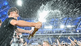 Feiernde Menschen werden von einer Bierdusche getroffen.