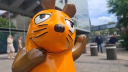 Die reparierte Skulptur der WDR Maus an ihren angestammten Platz in Köln