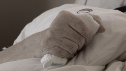 Die Hand einer älteren Person, die ein Handtuch fest umschließt