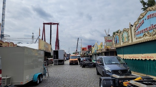 Eine Straße mit vielen Buden, daneben zahlreiche Transporter und LKW
