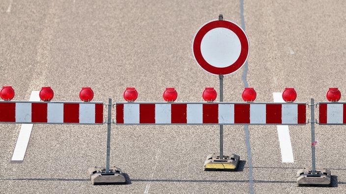 Eine mehrspurige Autobahn, die mit einem Schrankenzaun und einem Schild abgesperrt ist