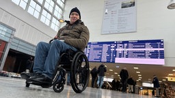 Michael Spörke sitzt im Rollstuhl und ist in der Halle des Duisburger Hauptbahnhofes