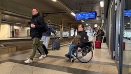 Wolfgang Thiems steht mit seinem Rollstohl an einem Gleis am Bahnhof Köln Messe/Deutz