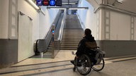 Wolfgang Thiems steht mit seinem Rollstohl vor den Treppen, die zum Bahngleis führen