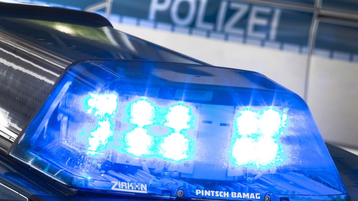 Auf dem Foto ist ein Blaulicht der Polizei, dahinter die Aufschrift "Polizei" an einem Auto.