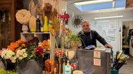 Ein Mann steht in einem Blumenladen hinter der Theke