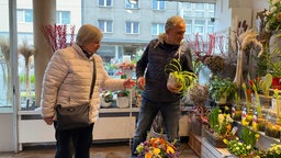 Kundin und Verkäufer in einem Blumenladen