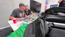 Zwei Männer betrachten den Bildschirm eines Laptops