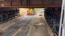 Eine Holzplatte fällt von einer Brücke auf eine gesperrte Autobahn.