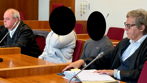 Die zwei Angeklagten sitzen mit ihren Verteidigern im Bonner Gericht