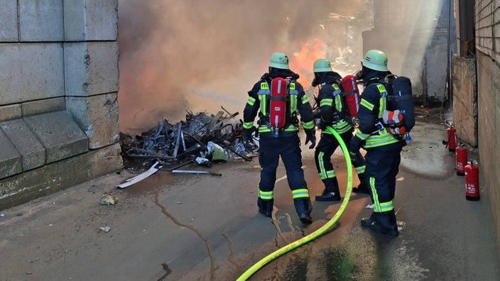 Einsatzkräfte der Feuerwehr löschen einen Brand.