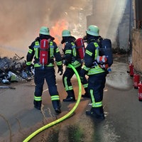 Einsatzkräfte der Feuerwehr löschen einen Brand.