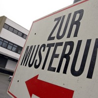 Schild mit der Aufschrift zur Musterung vor einem mehrstöckigen Gebäude