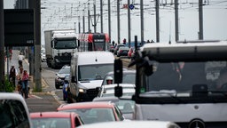 Viele Autos, Lkw und eine Stadtbahn drängeln sich auf einer Brücke
