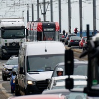 Viele Autos, Lkw und eine Stadtbahn drängeln sich auf einer Brücke