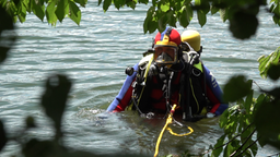 Taucher in Tauchermontur steht im Wasser