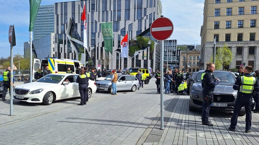 Mehrere Polizisten stehen an zwei Autos, um sie zu kontrollieren
