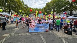 Eine Gruppe mit Anti-Abtreibungsplakaten. Die vorderen Personen halten ein Banner mit einem Spruch der auf Deutsch und Polnisch geschrieben steht.