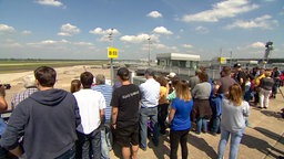 Viele Menschen stehen auf einer Aussichtsplattform am Flughafen Düsesldorf mit Blick aufs Rollfeld