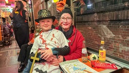 Zwei verkleidete Personen sitzen an Halloween in einer Bahn
