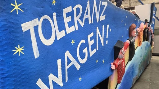Ein großer "Toleranzwagen"-Schriftzug auf blauem Hintergrund
