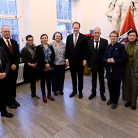 Mehrere Menschen in einer Reihe nebeneinander in einem Saal