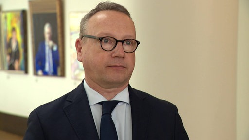 Ein Mann in Anzug, Benjamin Limbach, blickt in die Kamera