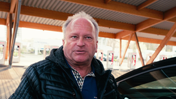 Ein Kunde der Ladestation in Hilden vor den Säulen.