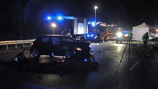 Die Unfallszene auf der A3: Einsatzwagen mit Blaulicht stehen hinter einem Unfallauto.