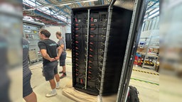 Die schwarzen Batteriepakete neben Voltfang Mitarbeitern
