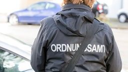 Eine Ordnungsämtlerin verteilt Strafzettel
