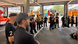 Einsatzkräfte der Feuerwehr stehen in einem Gebäude 