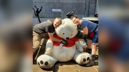 Das Bild zeigt Fluthelfer mit dem Teddy.