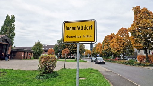 Blick auf den Ortseingang von Inden mit Schild