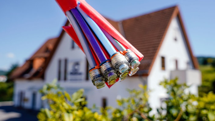 Blick auf ein Glasfaserkabel, dahinter ein Haus