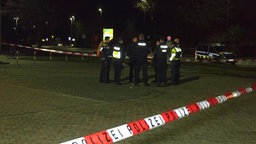 Polizisten sind an einem abgesperrten Tatort