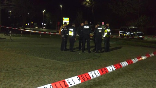 Polizisten sind an einem abgesperrten Tatort
