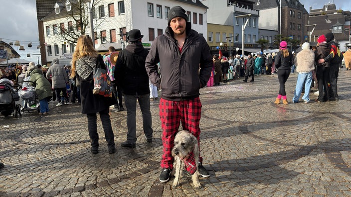 Ein Mann und sein Hund tragen ein Karnevalskostüm im Partnerlook