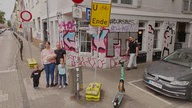 Die Familie steht vor dem Hotel, in dem sie aktuell wohnt.