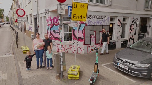 Die Familie steht vor dem Hotel, in dem sie aktuell wohnt.