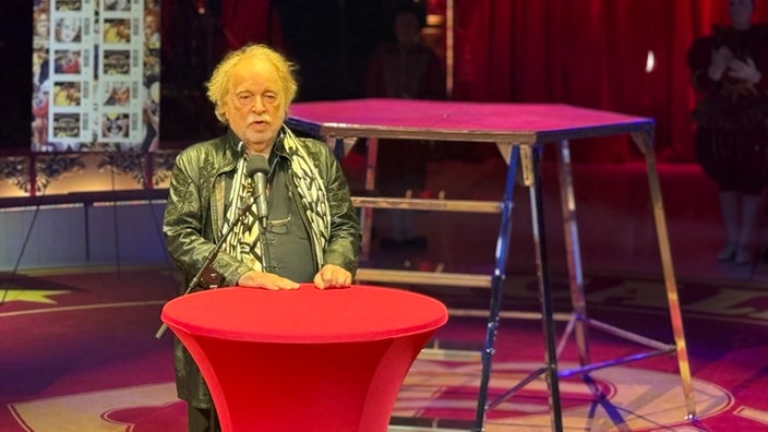 Bernhard Paul steht an einem Stehtisch mit roter Tischdecke